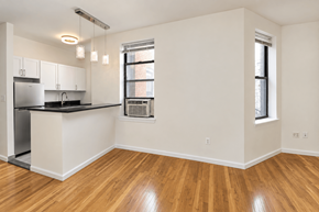 New York apartment for rent - A kitchen with white cabinets and a black countertop.