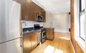 New York apartment for rent - A kitchen with wooden cabinets and stainless steel appliances.