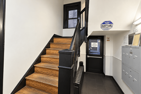 New York apartment for rent - A staircase with a black railing and wooden steps.