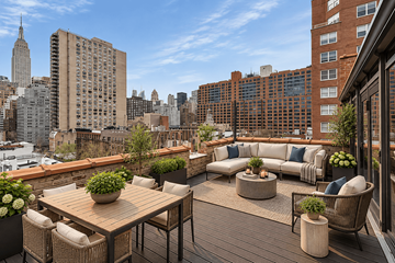 New York triplex for rent - A wooden table with chairs and a couch on a balcony with a view of the city.