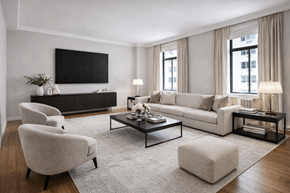 New York apartment for rent - A modern living room with a grey sofa, a white armchair, a coffee table, and a flat-screen TV mounted on the wall.