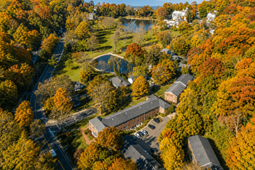 Roslyn apartment for rent - A small building is surrounded by trees with autumn leaves.
