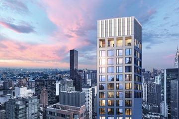 New York apartment for rent - A modern skyscraper stands tall in a cityscape at dusk.