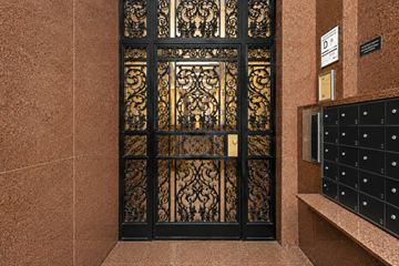 New York apartment for rent - A black and gold patterned door with a sign above it.