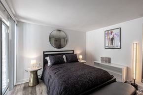Wallingford apartment for rent - A bedroom with a large bed and a round mirror on the wall.