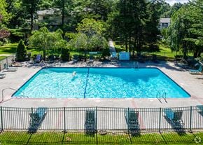 Wallingford apartment for rent - A large swimming pool surrounded by a black fence and lounge chairs.