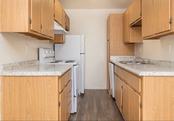 Tucson apartment for rent - A kitchen with wooden cabinets and a white fridge.