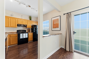 Jonesboro townhouse for rent - A kitchen with wooden cabinets and black appliances is shown.
