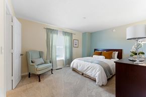 Jonesboro townhouse for rent - A bedroom with a bed, chair, and lamp.