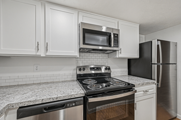 Lancaster townhouse for rent - A kitchen with a black stove top oven and a black microwave above it.