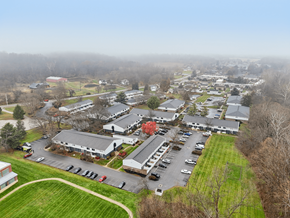 Lancaster townhouse for rent - A large building complex with a parking lot in front.