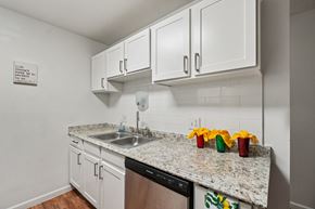 Pontiac apartment for rent - A kitchen with white cabinets and a granite countertop.