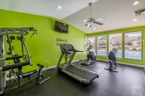 Pontiac apartment for rent - a gym with treadmills and other exercise equipment and a tv