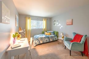 Pontiac apartment for rent - A bedroom with a bed, a chair, and a desk.