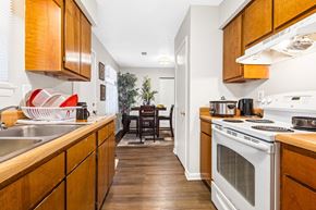 Newnan apartment for rent - A kitchen with wooden cabinets and a white oven.