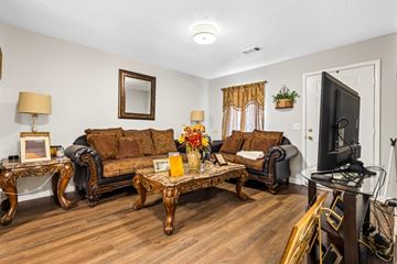 Newnan apartment for rent - A living room with a brown sofa and a wooden coffee table.