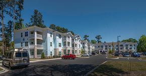 Wilmington apartment for rent - A red car is parked on the side of a road in front of a building.