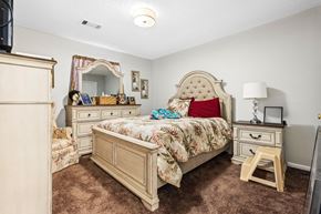 Newnan apartment for rent - A bedroom with a large bed and a vanity table.