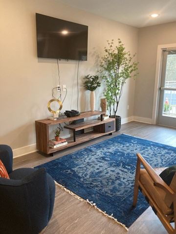 Atlanta apartment for rent - A living room with a blue rug and a wooden chair.
