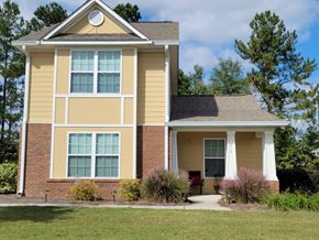 Aiken apartment for rent - a yellow house with a lawn in front of it