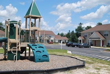 Jacksonville apartment for rent - A playground with a green slide and a wooden tower.