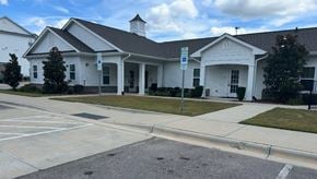 Raleigh apartment for rent - A white building with a black roof and a parking lot in front.