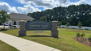 Raleigh apartment for rent - A sign for Abbington Village stands in front of a building and trees.