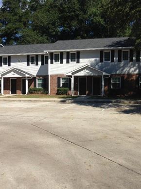 Ridgeland apartment for rent - A white building with a black roof and a parking lot in front.