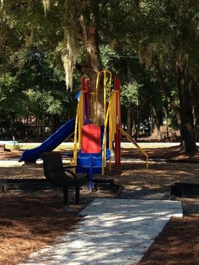 Ridgeland apartment for rent - A playground with a blue slide and a red and yellow structure.