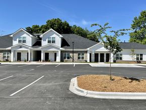 Charlotte apartment for rent - A large white building with a parking lot in front.