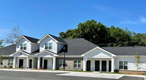 Charlotte apartment for rent - A two-story house with a white exterior and a black roof.