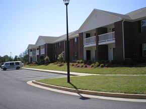 Toccoa apartment for rent - A street view of a building with a white van parked in front.