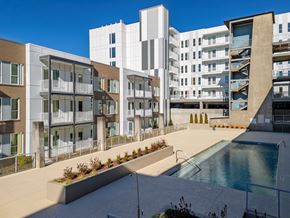 Atlanta apartment for rent - A modern apartment complex with a pool in the foreground.