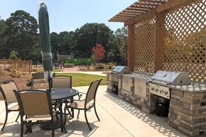 Mableton apartment for rent - A patio with a table and chairs and a grill.