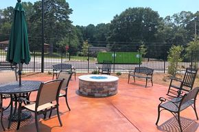 Mableton apartment for rent - A patio with a table, chairs, and an umbrella.