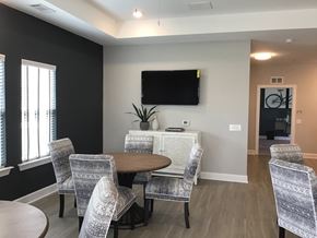 Raleigh apartment for rent - A conference room with a television mounted on the wall and a round table surrounded by chairs.