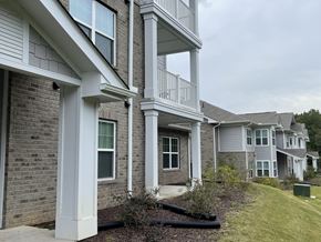 Lancaster apartment for rent - A row of houses with a white column in the foreground.