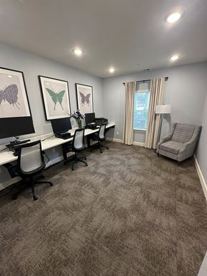 Elberton apartment for rent - A room with a carpeted floor and a desk with chairs.