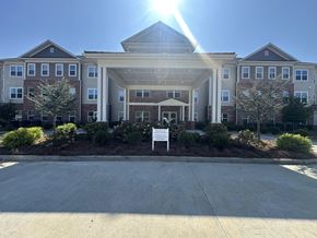 Elberton apartment for rent - A sunny day at a large, multi-story residential building with a driveway in front.