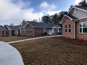 Winnsboro apartment for rent - A row of houses with a sidewalk in front.