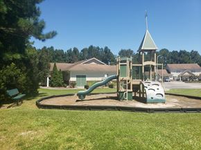 Jacksonville apartment for rent - A playground with a green slide and a wooden structure.