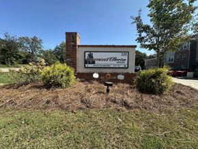 Elberton apartment for rent - A sign for a Wood Elberton office is in front of a brick chimney.