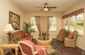 Newnan apartment for rent - A living room with a yellow coffee table and red chairs.