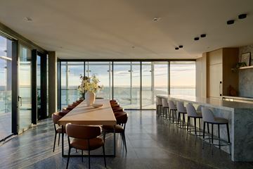 Seattle condo for rent - A dining room with a long table and chairs with a view of the outside.