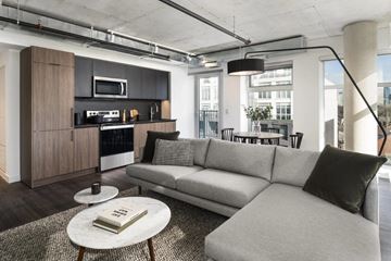 Toronto apartment for rent - A modern living room with a grey sofa and a coffee table.