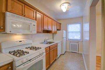 Fair Lawn apartment for rent - A kitchen with white appliances and wooden cabinets.