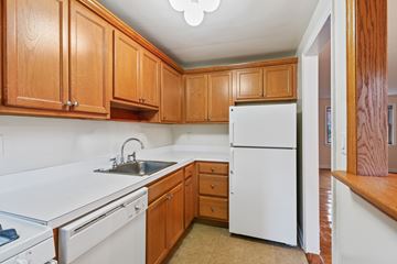 Fair Lawn triplex for rent - A kitchen with white appliances and wooden cabinets.