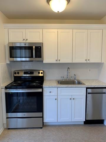 Atlantic Highlands apartment for rent - A kitchen with white cabinets and a black stove top oven.