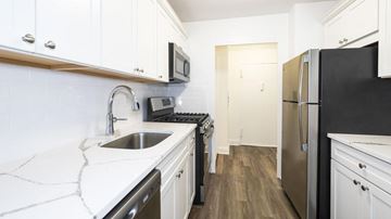 Caldwell apartment for rent - A kitchen with white cabinets and a black fridge.
