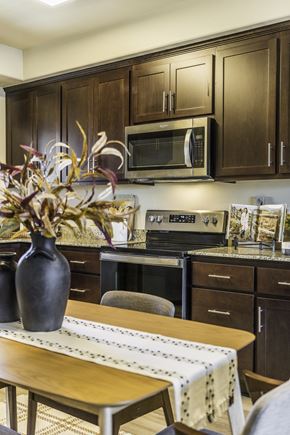 Salinas apartment for rent - A kitchen with brown cabinets and a wooden table.
